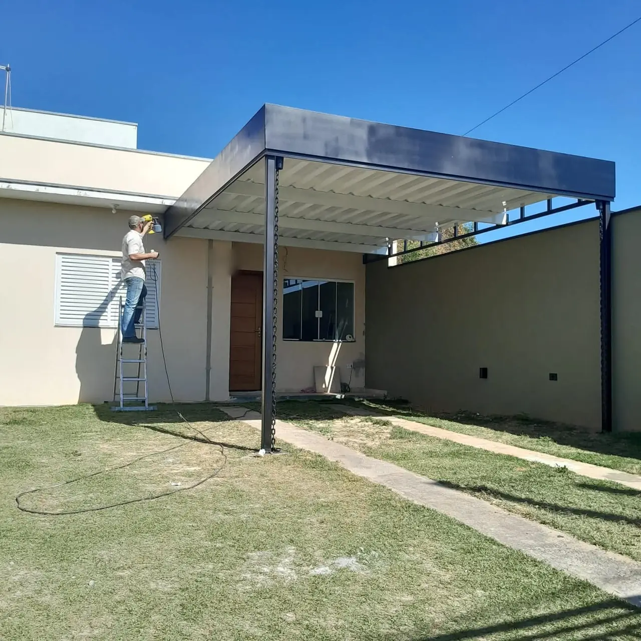 Cobertura metálica sendo pintada na obra