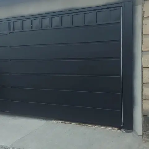 Portão preto instalado na garagem